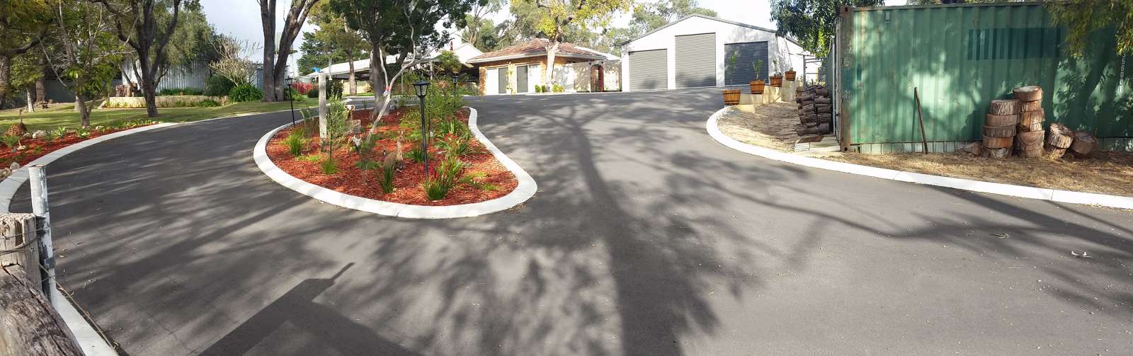 repair-driveways-with-asphalt-resurfacing-perth A previously damaged driveway now resurfaced with asphalt as an option for driveway repairs complete with custom central garden.